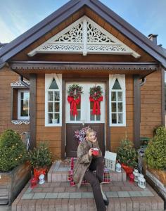 Eine Frau, die auf der Veranda eines Hauses sitzt. in der Unterkunft STACJA RUDA in Złota Wieś