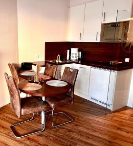 eine Küche mit Tisch und Stühlen in einem Zimmer in der Unterkunft Lord Nelson Apartment 14 in Cuxhaven