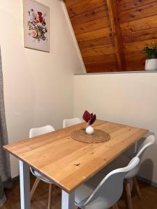 un tavolo di legno con sedie bianche e un soffitto di legno di Aurora A-Frame Twizel a Twizel Altre 17 foto