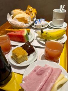 een tafel met borden van verschillende soorten levensmiddelen bij Hotel Sheik Business in Rio de Janeiro