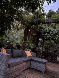 un divano seduto su un patio sotto un albero di Aurora A-Frame Twizel a Twizel