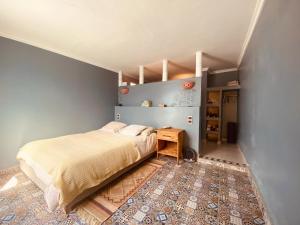 a bedroom with a bed and a wooden table at Charming room with balcony and ocean view in Essaouira
