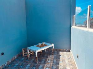 a blue room with a table and a window at Charming room with balcony and ocean view in Essaouira +25 photos