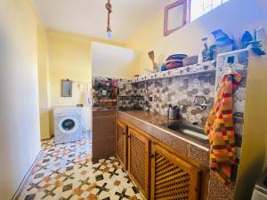 a kitchen with a sink and a washing machine at Charming room with balcony and ocean view in Essaouira