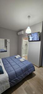 a bedroom with a large blue bed and a flat screen tv at ILBE bed & breakfast in Campobasso