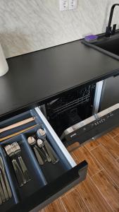 an open drawer in a kitchen with utensils at Stan na dan Jović in Modriča