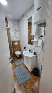 a bathroom with a white sink and a toilet at Stan na dan Jović in Modriča +3 photos