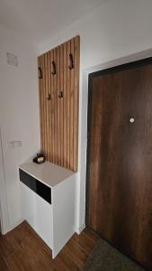 a room with a white desk next to a wooden door at Stan na dan Jović in Modriča