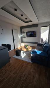 a living room with a blue couch and a table at Stan na dan Jović in Modriča
