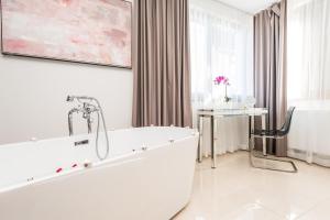 普利特维采村Plitvice Falls Cottage - Luxury rooms & Dinner的带浴缸和桌椅的浴室 更多45张照片