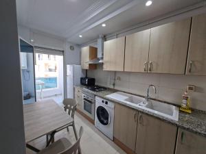突尼斯Lac 2 Luxury apartment C的配有桌子、水槽和炉灶的厨房