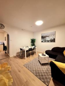 Dali 3 Ultra Central Stavanger City في ستافانغر: غرفة معيشة بها أريكة وطاولة +14 صورة