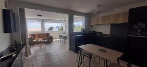 a kitchen and living room with a table and chairs at Beau duplex T3 avec une superbe vue mer in Le Diamant