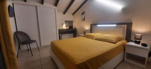 a bedroom with a bed and a chair in it at Beau duplex T3 avec une superbe vue mer in Le Diamant