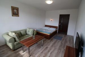 Habitación con cama, sofá y mesa. en Apartment Igor, en Lúčky