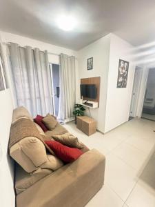a living room with a couch and a television at Cozy apartment near the airport in São José dos Pinhais