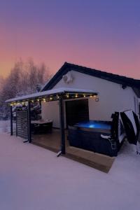 a gazebo with a bed in the snow at Domki Całoroczne PREMIUM Zator ENERGYLANDIA in Zator