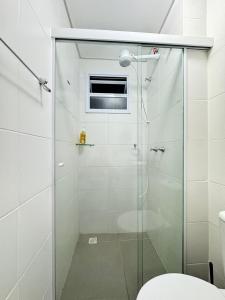 a glass shower in a bathroom with a toilet at Cozy apartment near the airport in São José dos Pinhais