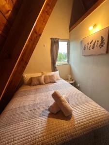 una camera da letto con un letto e un asciugamano sopra di Aurora A-Frame Twizel a Twizel