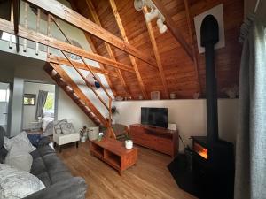 a living room with a couch and a wood stove at Aurora A-Frame Twizel in Twizel