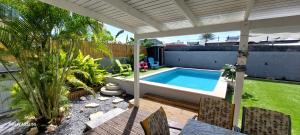 a backyard with a swimming pool on a patio at Villa Hibiscus in Sainte-Anne