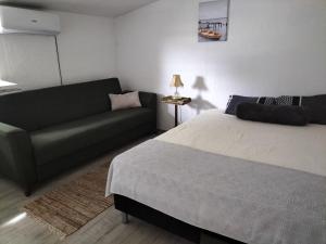a living room with a bed and a couch at Kuća za odmor SIG in Erdevik