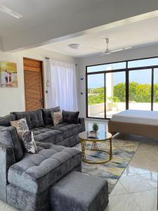 un soggiorno con un divano e un letto di Fantasea Villa a Ukunda Airport