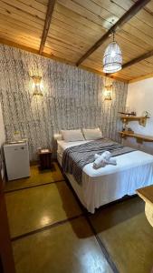 a bedroom with a bed with a robe on it at Pousada Barra Nova Praiamar in Cascavel +27 photos