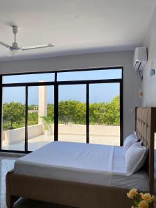 una camera da letto con un letto grande e una grande finestra di Fantasea Villa a Ukunda Airport