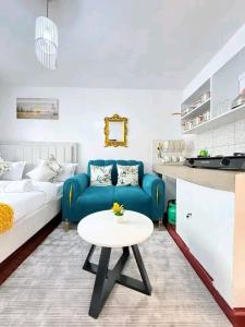 a living room with a blue couch and a table at Travel Nest in Nairobi