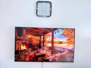 a television with a clock on top of a living room at Travel Nest in Nairobi +8 photos