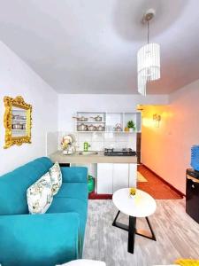 a living room with a blue couch and a kitchen at Travel Nest in Nairobi