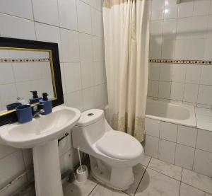 a bathroom with a toilet and a sink and a tub at Departamento bahia fonck in Puerto Montt