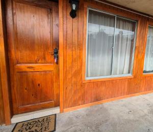a wooden door of a house with a window at Departamento bahia fonck in Puerto Montt