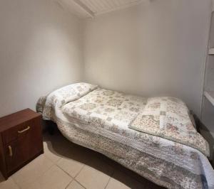 a small bedroom with a bed and a night stand at Departamento bahia fonck in Puerto Montt