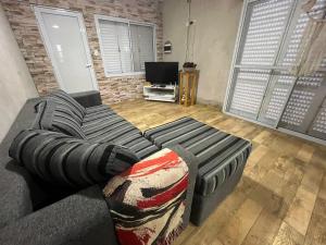 a living room with a couch and a television at Alojamiento luxur in San José