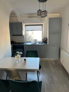 a kitchen with a white table and chairs in a room at Apartament The Office-Scorțarilor Cluj in Cluj-Napoca