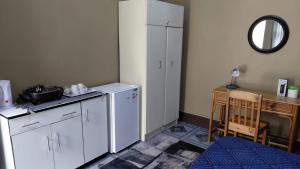 eine Küche mit einem weißen Kühlschrank neben einem Tisch in der Unterkunft Germiston Residential Motel in Germiston