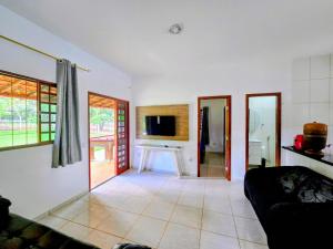 uma sala de estar com um sofá e uma TV em Chácara com piscina e lago aconchegantes em Planaltina