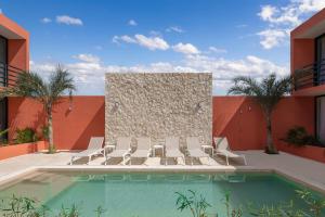 a swimming pool with lounge chairs and a wall at The Retreat at Sisal in Sisal