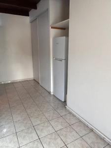 サント・リュスにあるGrand studio avec mezzanine à 5 min de la plageのタイルフロアの空き部屋(冷蔵庫付)