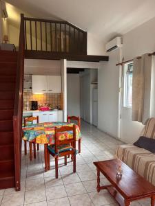 サント・リュスにあるGrand studio avec mezzanine à 5 min de la plageのテーブルとキッチンのあるリビングルーム