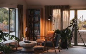 ein Wohnzimmer mit einem Stuhl und einem Bücherregal in der Unterkunft Domu Retreat in Kaiteriteri