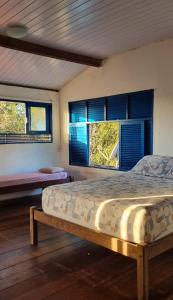 una camera da letto con un letto e due finestre di Casa luz a Pipa