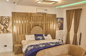 a bedroom with a bed with a large wooden headboard at 3M-Z Lekki Luxury Shortlet Duplex Apartment in Mama