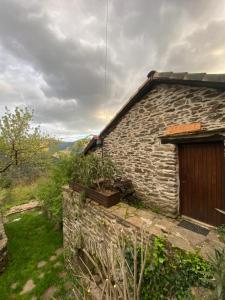 a stone house with a wooden door on the side of it at Maison rurale au cœur des Cévennes Ardéchoises in Dompnac