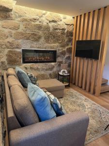 ein Wohnzimmer mit Sofa und Kamin in der Unterkunft Casas com Alma - O Palheiro - Gerês in Cabril