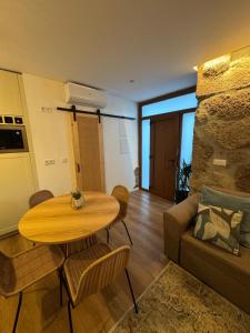 ein Wohnzimmer mit einem Tisch und einem Sofa in der Unterkunft Casas com Alma - O Palheiro - Gerês in Cabril