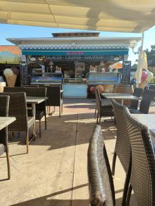 eine Außenterrasse mit Tischen und Stühlen und ein Restaurant in der Unterkunft Mobil-home climatisé 4 pers 2 chambres in Messanges