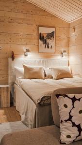 a bedroom with a large bed in a wooden wall at Kataja Chalet with sauna and jacuzzi in Rovaniemi +13 photos